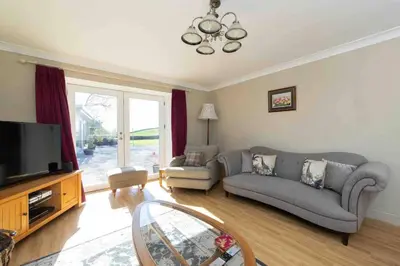 a living room with a couch and a tv at Amazing Cottage & detached Annex sleeps 8, Extra Deep Hot tub, Super Fast wifi, New for 2024 is the addition of Wood Fired Sauna in Castle Douglas