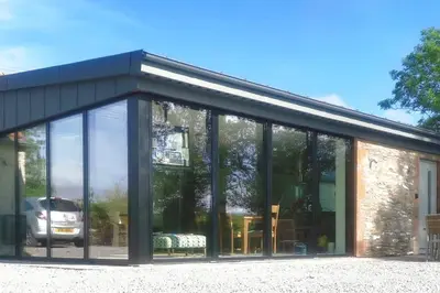 a glass house with a lot of windows at Amazing Cottage & detached Annex sleeps 8, Extra Deep Hot tub, Super Fast wifi, New for 2024 is the addition of Wood Fired Sauna in Castle Douglas