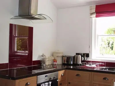 a kitchen with a black counter top and a window at Abbey Green, New Abbey, Dumfries and Galloway in Dumfries