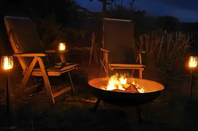 a fire pit at night with two chairs and lights at Abbey Green, New Abbey, Dumfries and Galloway in Dumfries