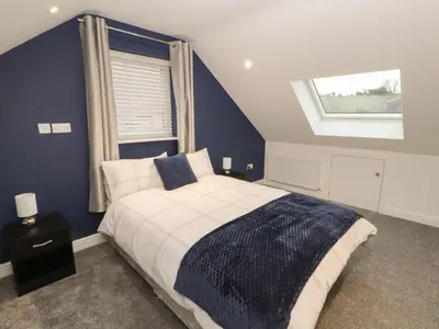 a bedroom with a large bed and a window at Beckside House in Cockermouth