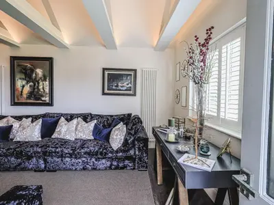 a living room with a couch and a table at Whisk Away Cottage in Penrith