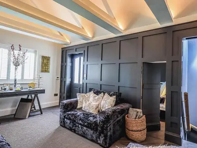 a living room with black walls and a couch at Whisk Away Cottage in Penrith