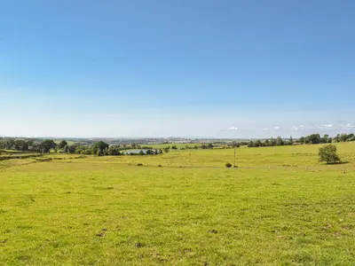 a field of green grass with a blue sky at Lowesmuir Cottage in Cumnock