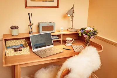 a desk with a laptop computer on top of it at High Clachan Farmhouse in Stranraer