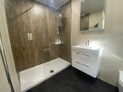 a white bathroom with a shower and a sink at Mountain Dream Cottage in Ramsey