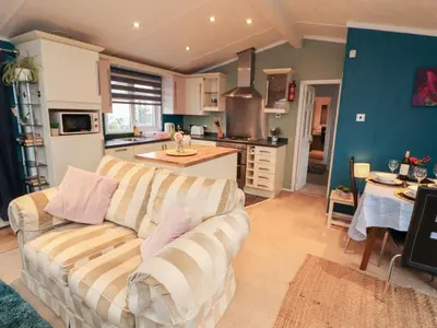 a living room with a couch and a kitchen at Rosie's Zen Den in Carlisle