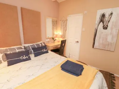 a bedroom with a large bed with blue pillows at Rosie's Zen Den in Carlisle