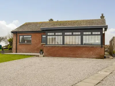 a brick house with a gravel driveway at Jura in Mainsriddle