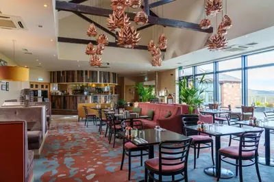 a restaurant with tables and chairs and windows at 12 Ullswater Suite - Whitbarrow Village in Penruddock