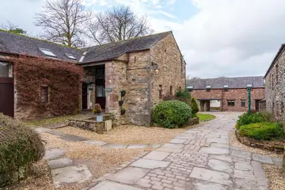 an old stone house with a cobblestone driveway at 12 Ullswater Suite - Whitbarrow Village in Penruddock