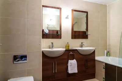 a bathroom with two sinks and a mirror at 12 Ullswater Suite - Whitbarrow Village in Penruddock