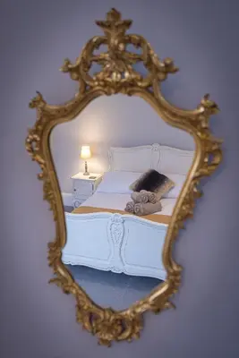 a mirror reflecting a bed with a stuffed animal on it at Spacious 1st Floor Apartment in Keswick