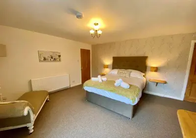 a bedroom with a large bed in a room at Elegant & spacious farmhouse with wonderful views in Penrith