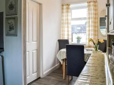 a dining room with a table and a window at Keepers Cottage in Dumfries