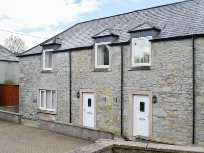 an old stone house with white doors and windows at Kirroughtree Steading 2 - Uk42904 in Newton Stewart