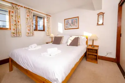 a bedroom with a large white bed in a room at Bens Cottage in Chapel Stile