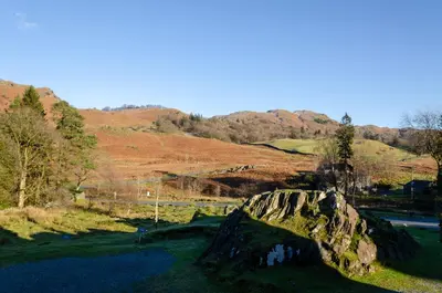 a large rock in a field with mountains in the background at Bens Cottage in Chapel Stile