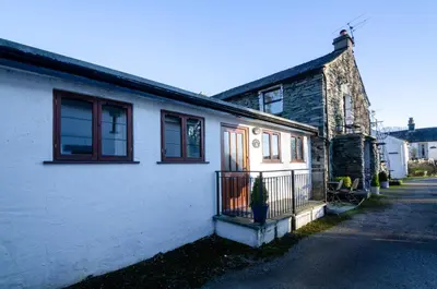 a white house with a potted plant in front of it at Bens Cottage in Chapel Stile