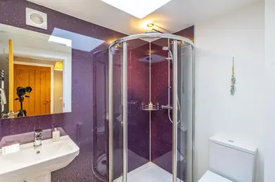a purple bathroom with a shower and a sink at Lord Galloway 31 with Hot Tub in Newton Stewart
