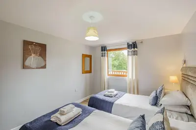 a bedroom with two beds and a window at Lord Galloway 32 with Hot Tub in Newton Stewart
