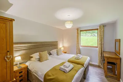 a bedroom with two beds and a window at Lord Galloway 32 with Hot Tub in Newton Stewart