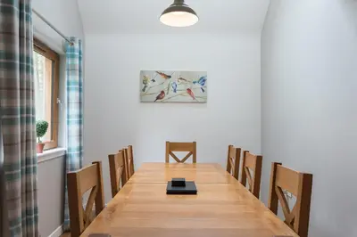 a dining room with a long table and chairs at Lord Galloway 33 with Hot Tub in Newton Stewart