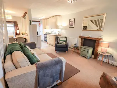 a living room with a couch and a fireplace at The Old Betting Shop in Keswick