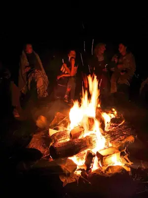 a group of people sitting around a bonfire at night at Ranch House in Newton Stewart
