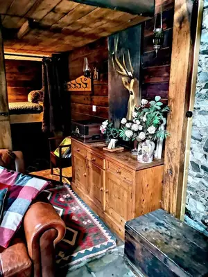 a room with a wooden cabin with a bed and a table at Ranch House in Newton Stewart