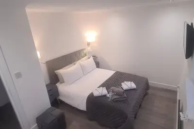 a small bedroom with a bed with white sheets at Stunning Refurbished 1 Bedroom, Harbour Apartment. in Ayr