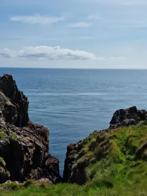 a view of the ocean from a hill with rocks at Stunning Caravan Whithorn3 in Newton Stewart