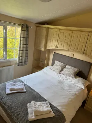 a bedroom with a large bed with towels on it at Stunning Caravan Whithorn3 in Newton Stewart