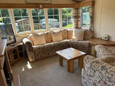 a living room with a couch and a table at Stunning Caravan Whithorn3 in Newton Stewart