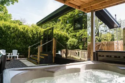 a hot tub in the backyard of a house at Reflections, Netherby, a micro cabin with hot tub in a rural setting in Longtown