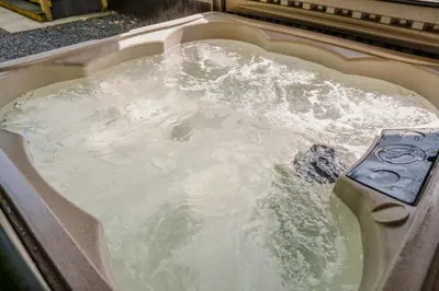 a bath tub filled with water in a sink at Reflections, Netherby, a micro cabin with hot tub in a rural setting in Longtown
