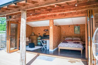 a bedroom with a bed and a desk in a room at The Chard, Netherby, a micro cabin in a rural setting with a hot tub in Longtown