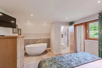 a large bathroom with a tub and a bath tub at Lord Galloway 38 with Hot Tub in Newton Stewart