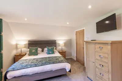 a bedroom with a bed and a flat screen tv at Lord Galloway 38 with Hot Tub in Newton Stewart