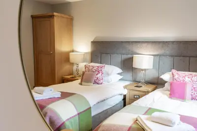 a hotel room with two beds and a mirror at Lord Galloway 38 with Hot Tub in Newton Stewart