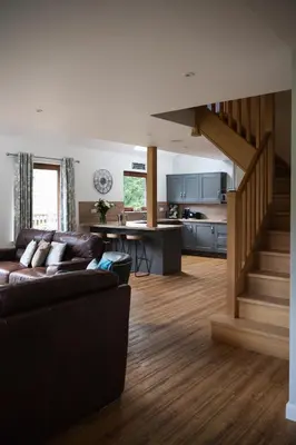 a living room with a couch and a kitchen at Lord Galloway 38 with Hot Tub in Newton Stewart