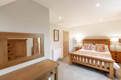 a bedroom with a bed and a large mirror at Lord Galloway 39 with Hot Tub in Newton Stewart
