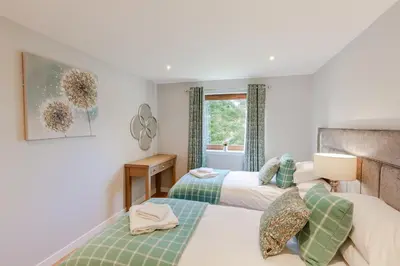a bedroom with two beds and a window at Lord Galloway 39 with Hot Tub in Newton Stewart