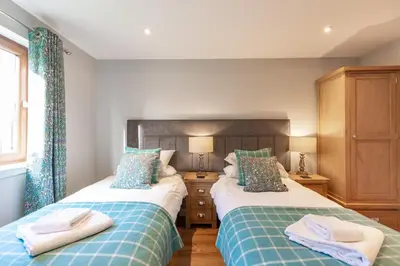 two beds sitting next to each other in a bedroom at Lord Galloway 39 with Hot Tub in Newton Stewart