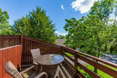 a patio with a table and chairs on a deck at Bluebell Lodge 3 with Hot Tub in Newton Stewart