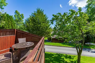 a wooden fence with a table and a table at Bluebell Lodge 3 with Hot Tub in Newton Stewart