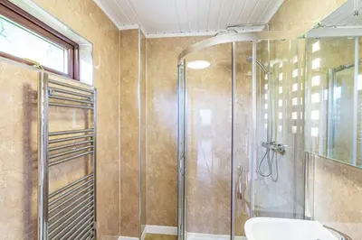 a bathroom with a shower with a toilet and a sink at Bluebell Lodge 3 with Hot Tub in Newton Stewart