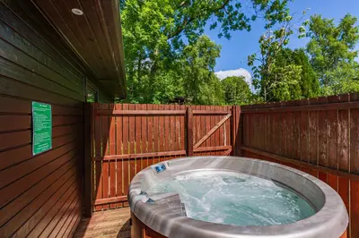 a hot tub on the side of a wooden fence at Bluebell Lodge 3 with Hot Tub in Newton Stewart