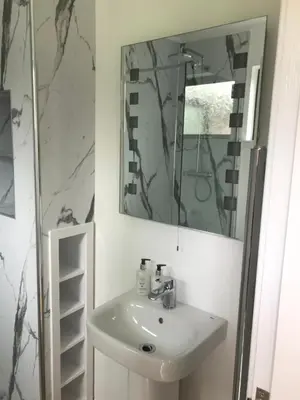 a bathroom with a sink and a mirror at Birch Lodge 17 with Hot Tub in Newton Stewart