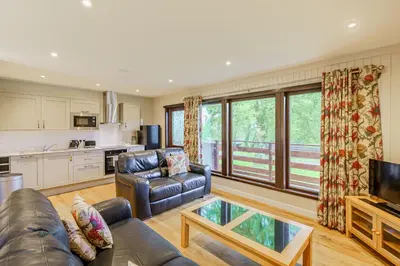 a living room with a couch and a table at Bluebell Lodge 4 with Hot Tub in Newton Stewart